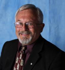 len beckman picture with tie and blue background
